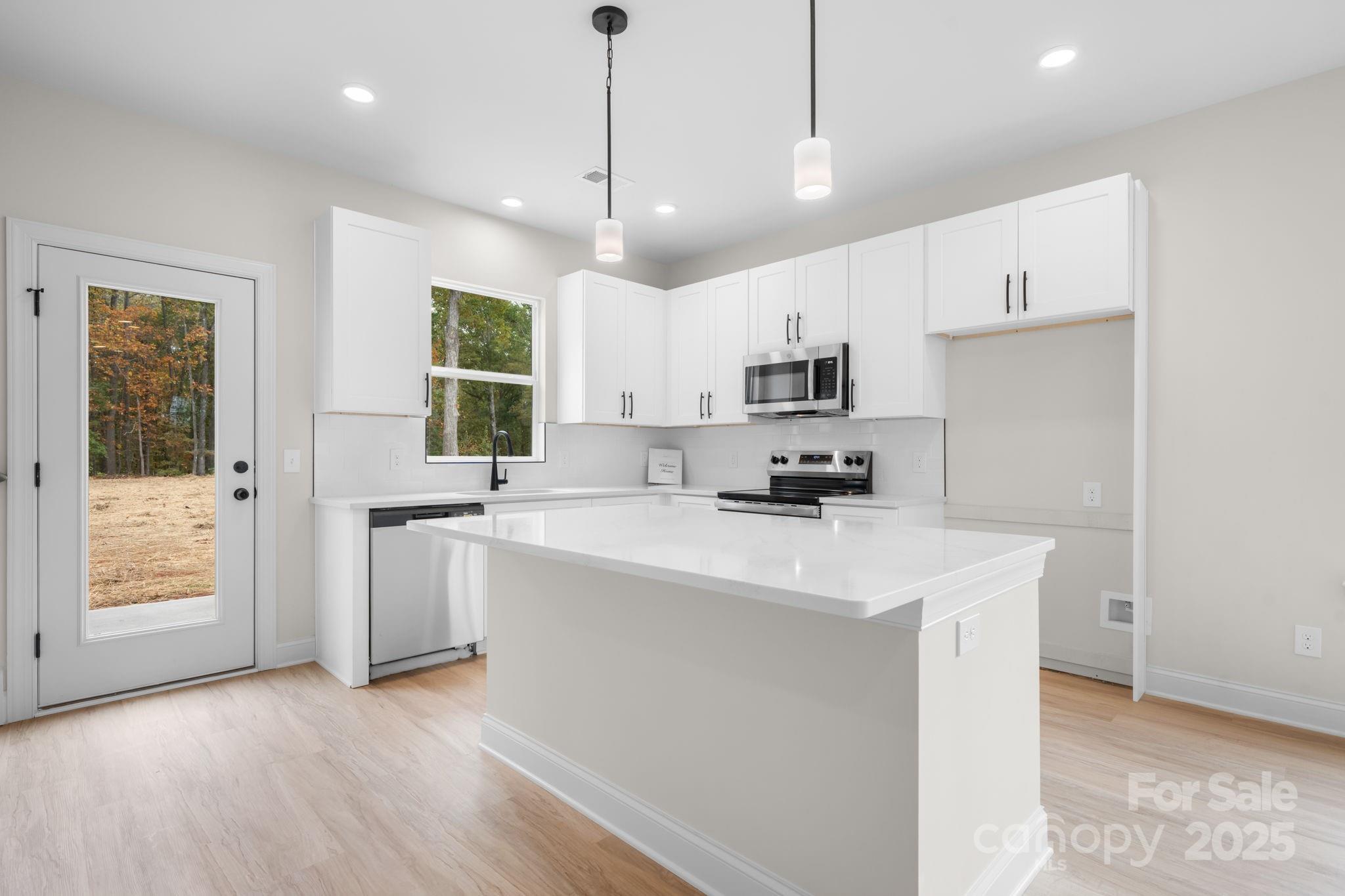 1888 Sigmon Dairy Road Newton, NC 28658 - Photo 2 of 38 a kitchen with kitchen island white cabinets and refrigerator