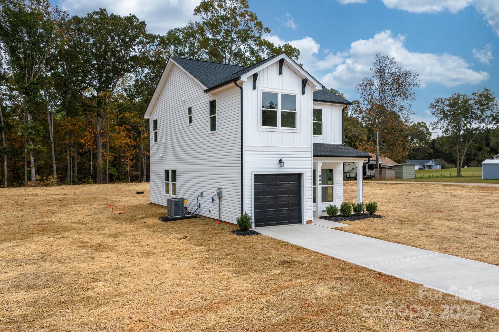 1888 Sigmon Dairy Road Newton, NC 28658 - Photo 32 of 38 a view of a white house with a yard and large tree