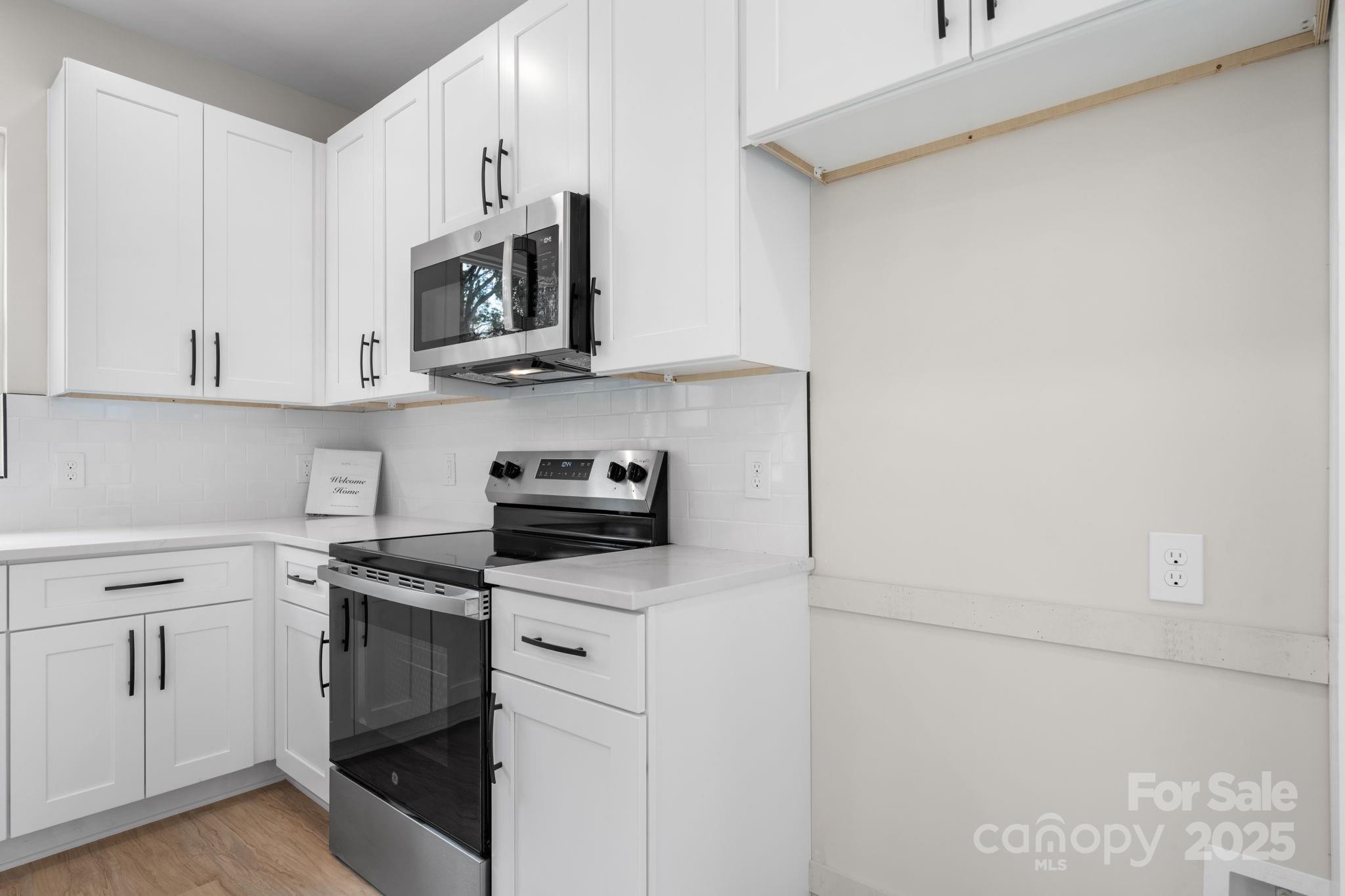 1888 Sigmon Dairy Road Newton, NC 28658 - Photo 6 of 38 a kitchen with white cabinets and stainless steel appliances