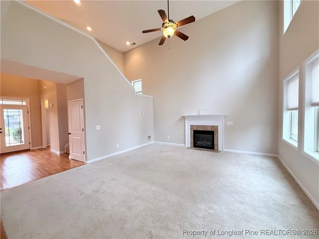 a view of an empty room with a fireplace and a window