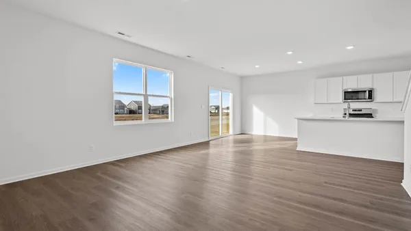 a view of a kitchen with wooden floor and electronic appliances