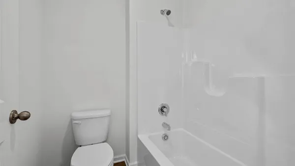 a white toilet sitting next to a bath tub