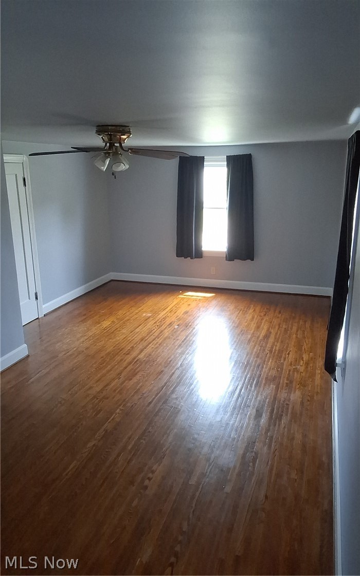 236 Bowland Road Mansfield, OH 44907 - Photo 30 of 34 Spacious room featuring wood-finish flooring, light gray walls, a ceiling fan with integrated lighting, white baseboards, and a double window