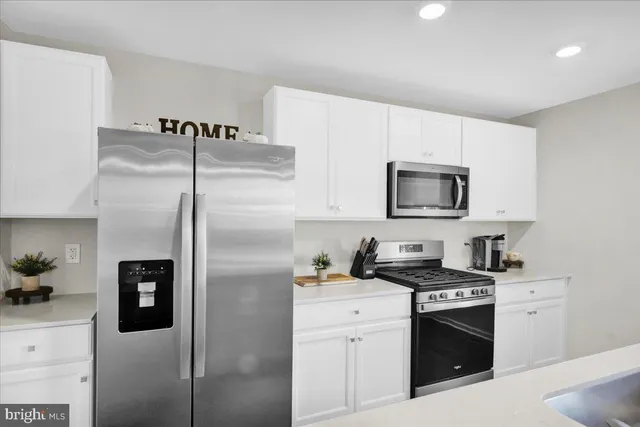 a kitchen with stainless steel appliances a refrigerator stove and microwave