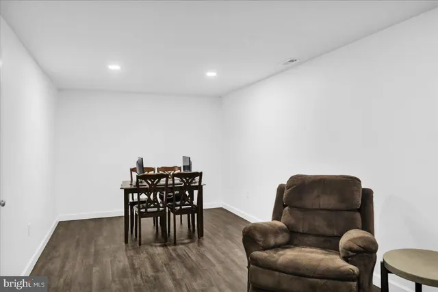 a living room with furniture and a dining table with wooden floor