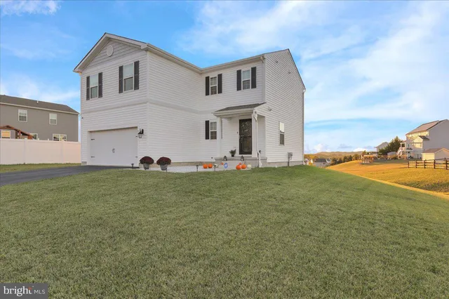 a front view of house with yard and car parked