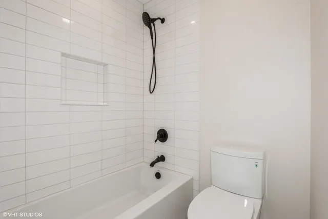 a bathroom with a toilet and a shower