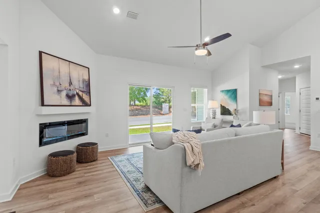 a living room with furniture a flat screen tv and a fireplace