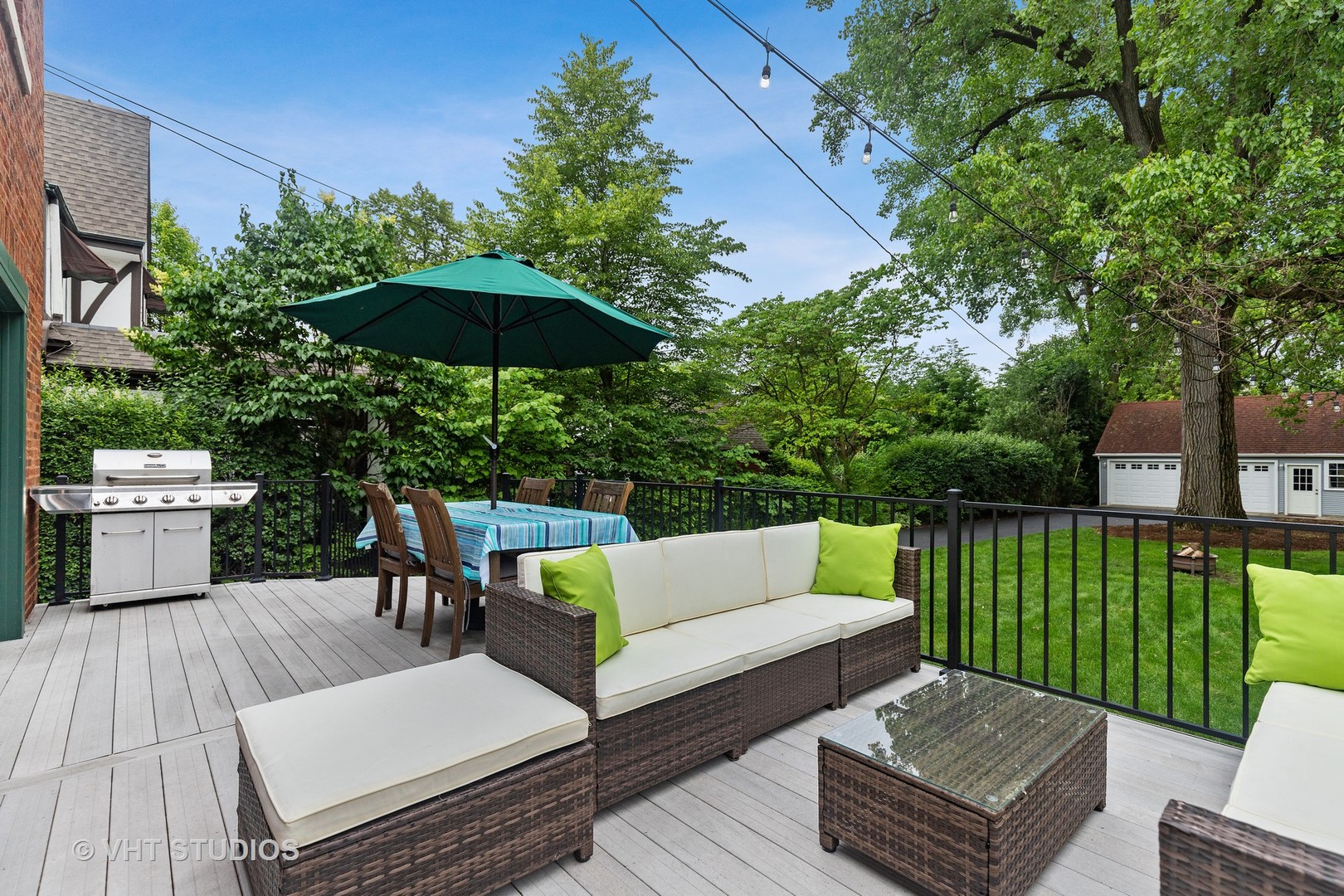 255 Addison Road Riverside, IL 60546 - Photo 21 of 24 a view of a patio with couches table and chairs under an umbrella with wooden floor and fence
