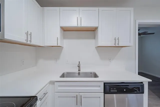 a kitchen with stainless steel appliances a refrigerator a sink dishwasher with a dining table and chairs