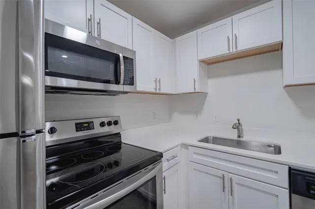 a kitchen with stainless steel appliances and white cabinets