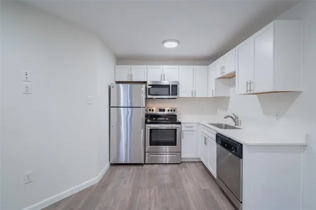 a view of a kitchen with white cabinets
