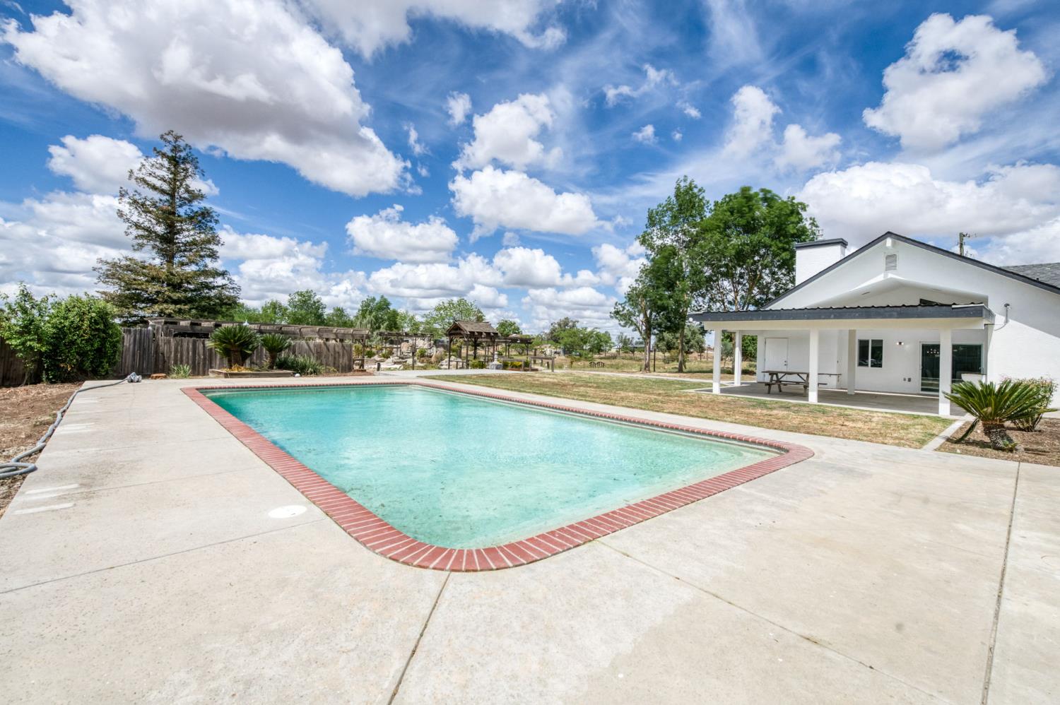 16564 Monreal Road Madera, CA 93636 - Photo 32 of 59 a view of a house with swimming pool and a yard