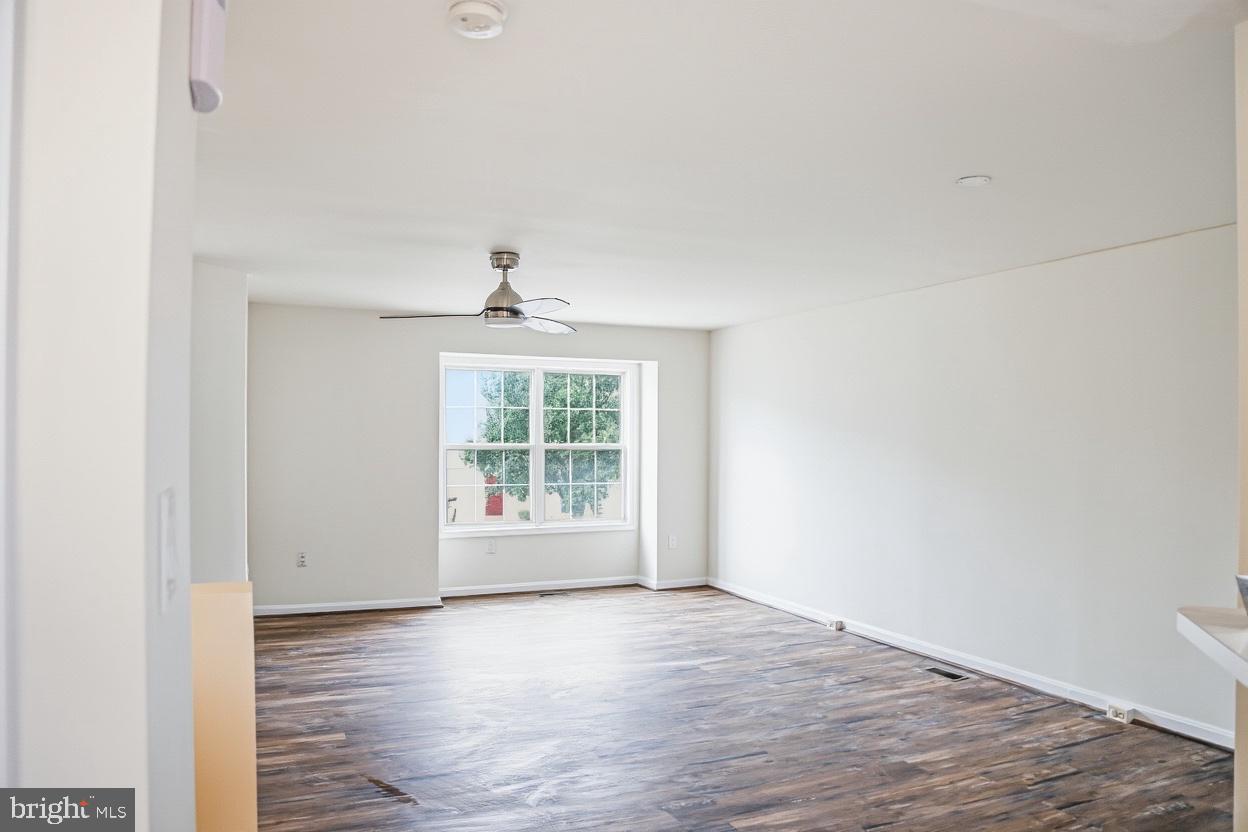 8461 Tackhouse Loop Gainesville, VA 20155 - Photo 3 of 10 a view of an empty room with wooden floor and a window