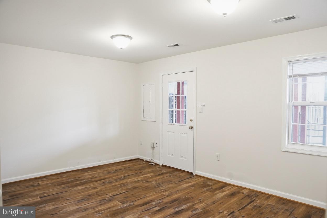 8461 Tackhouse Loop Gainesville, VA 20155 - Photo 4 of 10 an empty room with wooden floor and windows