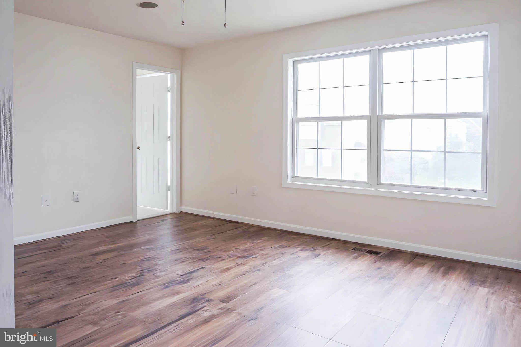 8461 Tackhouse Loop Gainesville, VA 20155 - Photo 5 of 10 an empty room with wooden floor and windows