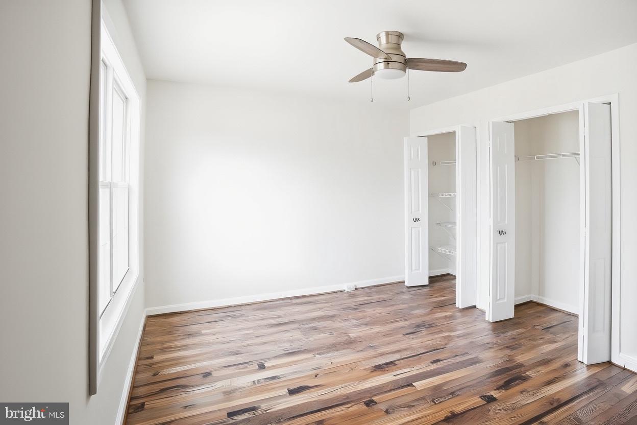 8461 Tackhouse Loop Gainesville, VA 20155 - Photo 6 of 10 a view of a room with wooden floor and a ceiling fan