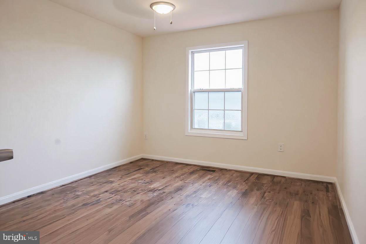 8461 Tackhouse Loop Gainesville, VA 20155 - Photo 7 of 10 an empty room with wooden floor and windows