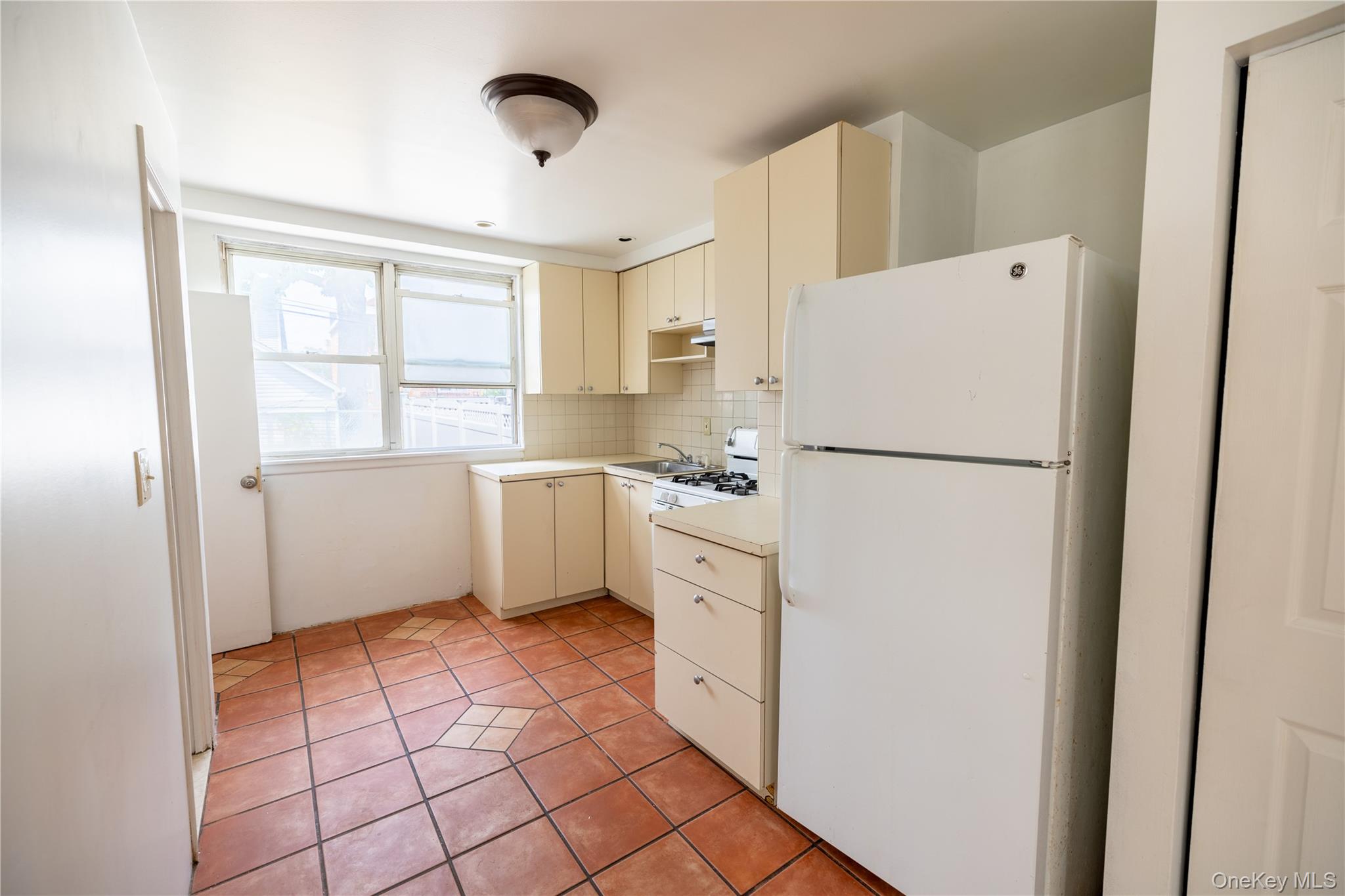 2941 Middletown Road Bronx, NY 10461 - Photo 10 of 31 a kitchen with a refrigerator a stove top oven and cabinets