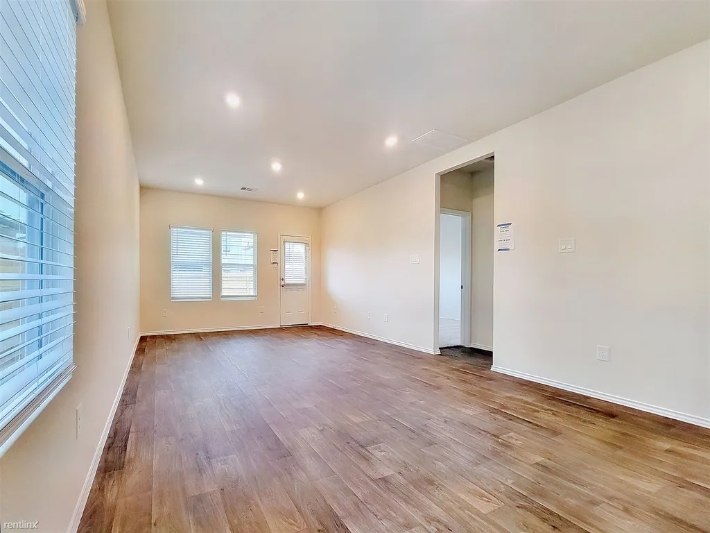 419 Sickle Loop Kyle, TX 78640 - Photo 11 of 35 Hardwood-style flooring and abundant recessed lighting enhance this airy open-concept living space.