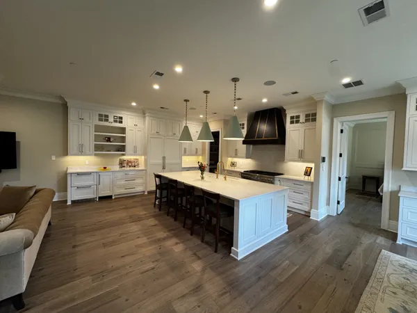 a large kitchen with stainless steel appliances granite countertop a lot of cabinets and wooden floor