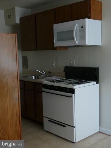 1200 South Arlington Ridge Road, Unit 315 Arlington, VA 22202 - Photo 9 of 12 a kitchen with stainless steel appliances granite countertop a stove and a microwave