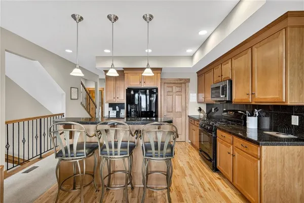 a kitchen with stainless steel appliances granite countertop a stove a sink and a microwave
