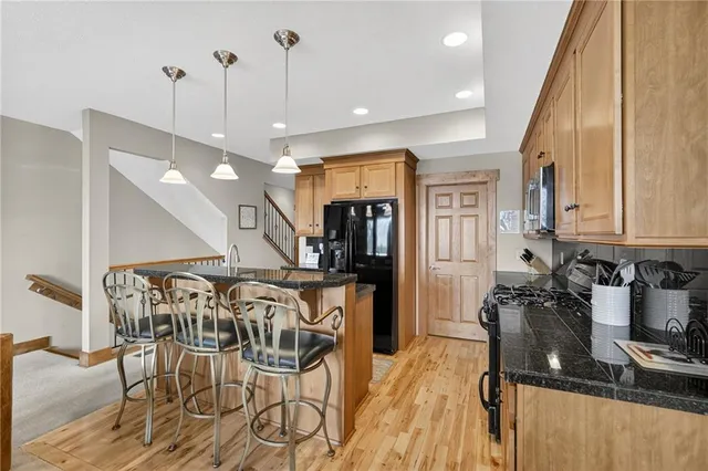 a kitchen with stainless steel appliances granite countertop a stove a sink and a microwave