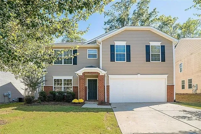 a front view of a house with yard and green space