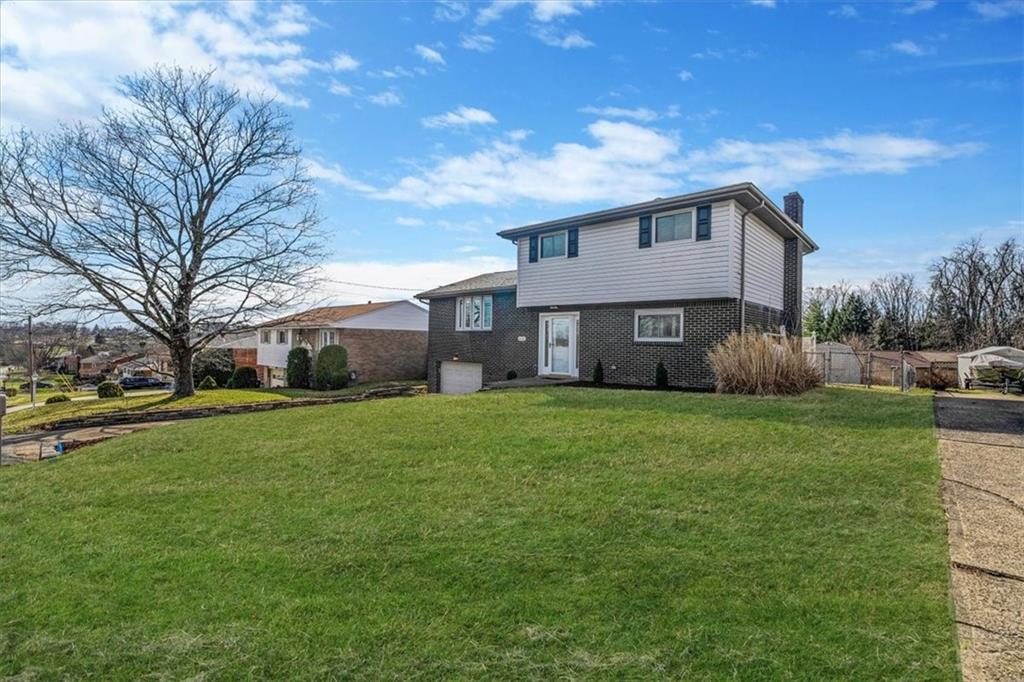 14190 Ridge Road Irwin, PA 15642 - Photo 2 of 49 a front view of a house with a garden and trees
