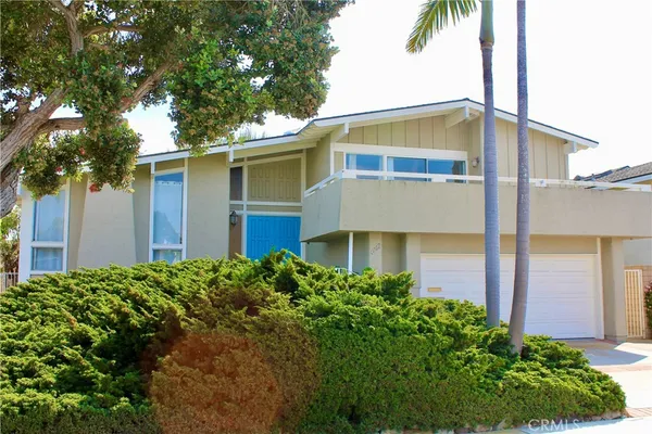 a front view of house with yard and trees around