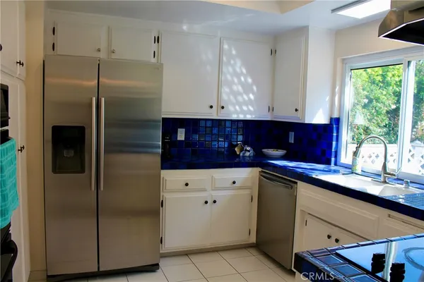 a kitchen with stainless steel appliances granite countertop a refrigerator and a sink