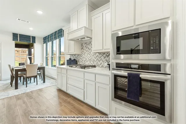 a large kitchen with kitchen island a sink a stove a dining table and chairs