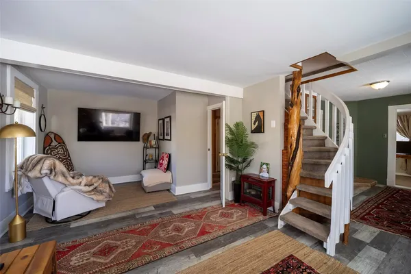 a living room with wooden floor and a rug