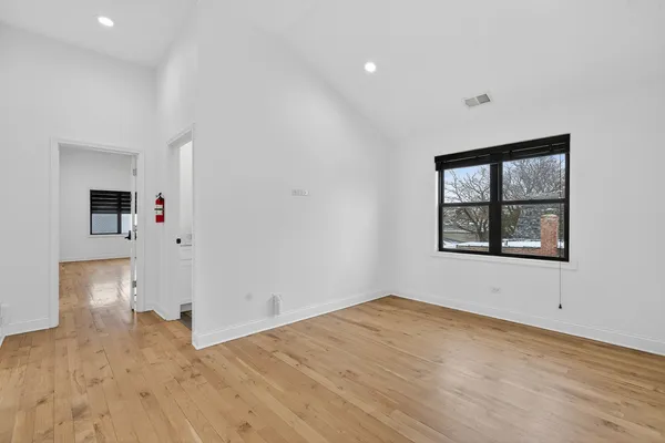 a view of empty room with wooden floor