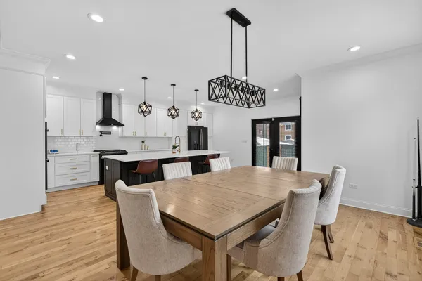 a view of a dining room and livingroom with furniture wooden floor a chandelier