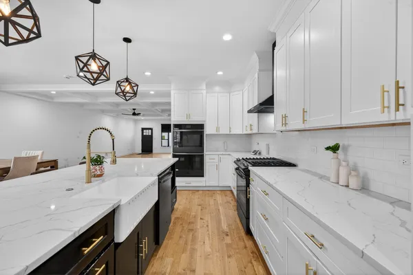 a kitchen with kitchen island granite countertop stainless steel appliances a sink a stove and cabinets
