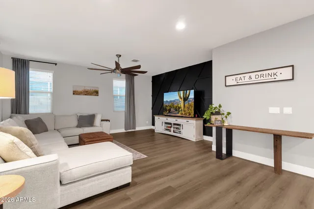 a kitchen with stainless steel appliances granite countertop a stove a sink a microwave a refrigerator and white cabinets with wooden floor