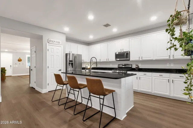 a kitchen with stainless steel appliances granite countertop a stove a sink and a refrigerator