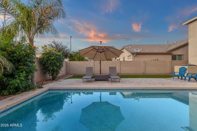 a view of a patio with a table and chairs under an umbrella