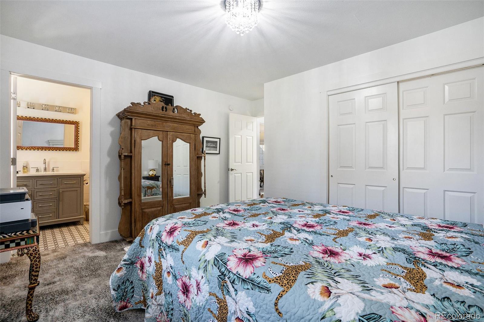 1600 South Quebec Way, Unit 10 Denver, CO 80231 - Photo 16 of 29 a bedroom with a bed and a chandelier