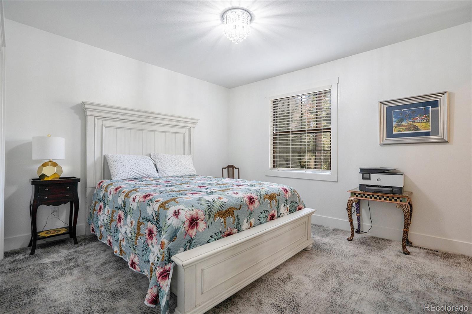 1600 South Quebec Way, Unit 10 Denver, CO 80231 - Photo 17 of 29 a bedroom with a bed and a chandelier