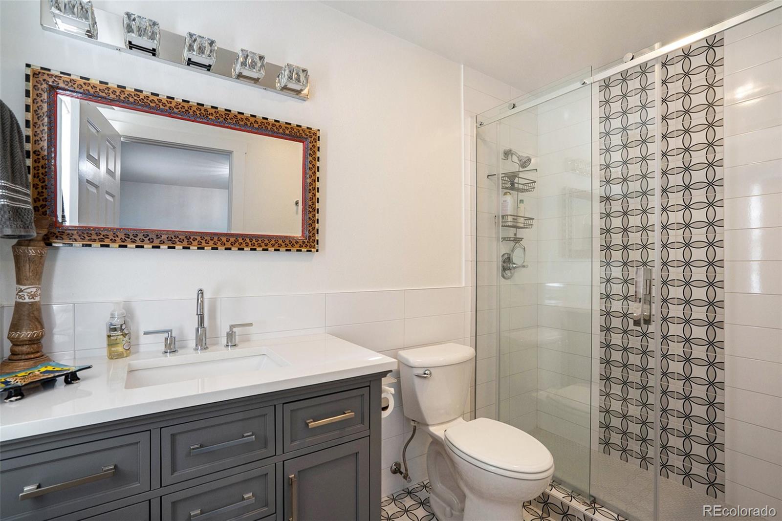 1600 South Quebec Way, Unit 10 Denver, CO 80231 - Photo 18 of 29 a bathroom with a toilet a sink a mirror a shower and vanity