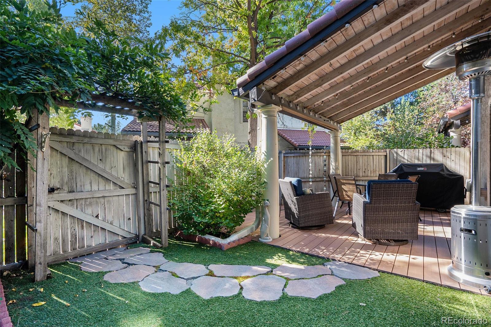 1600 South Quebec Way, Unit 10 Denver, CO 80231 - Photo 27 of 29 a view of backyard with table and chairs potted plants and wooden fence
