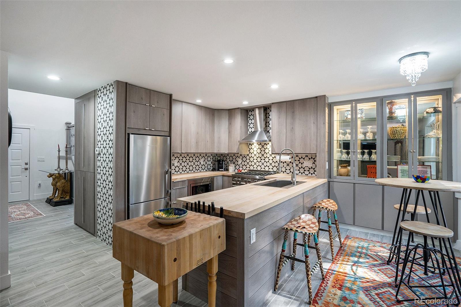 1600 South Quebec Way, Unit 10 Denver, CO 80231 - Photo 5 of 29 a kitchen with stainless steel appliances kitchen island granite countertop a refrigerator a stove a sink a dining table and chairs with wooden floor