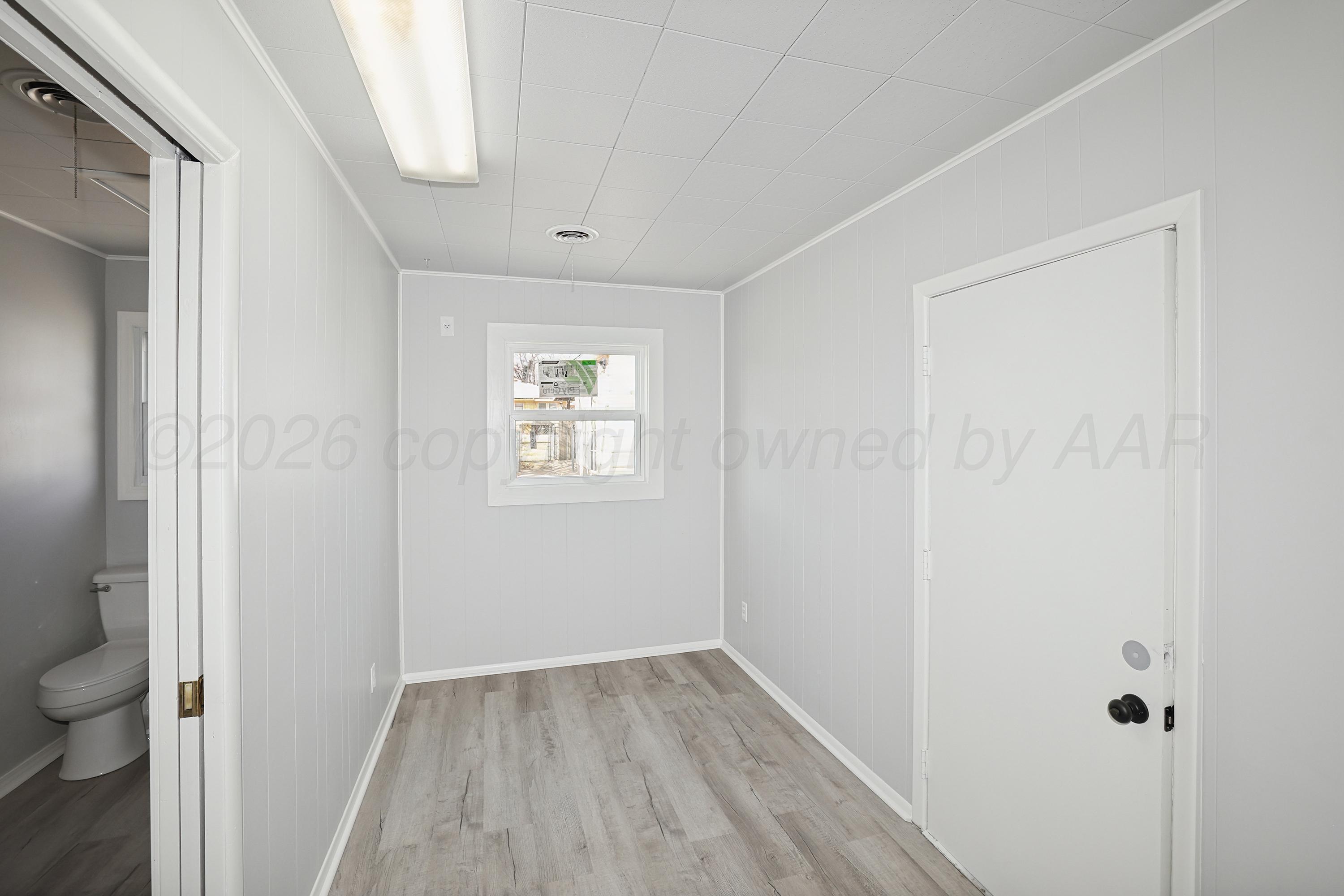 1602 Tularosa Street Amarillo, TX 79102 - Photo 12 of 33 a view of an empty room with wooden floor and a window