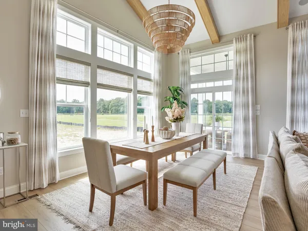 a dining room with furniture a chandelier and wooden floor