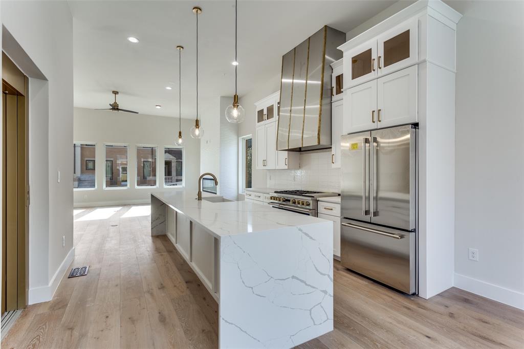 250 East Dallas Road, Unit 114 Grapevine, TX 76051 - Photo 15 of 33 a kitchen with stainless steel appliances granite countertop a refrigerator a stove and a wooden floors
