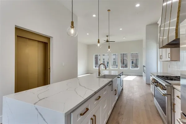 a kitchen with stainless steel appliances granite countertop a refrigerator a stove and a wooden floors