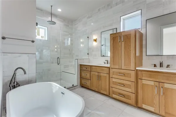 a bathroom with a tub sink toilet and shower